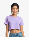 Woman wearing a purple crop top and blue jeans on a white background