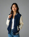 Woman wearing a navy blue varsity jacket 